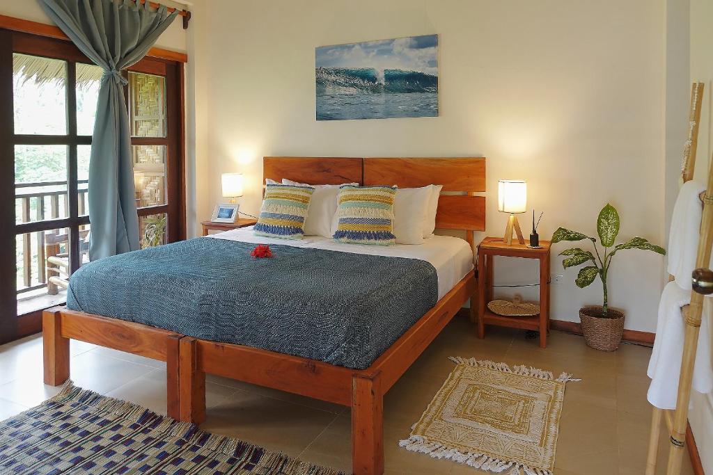 a bedroom with a bed with a blue comforter at Surfista Villa Siargao in General Luna