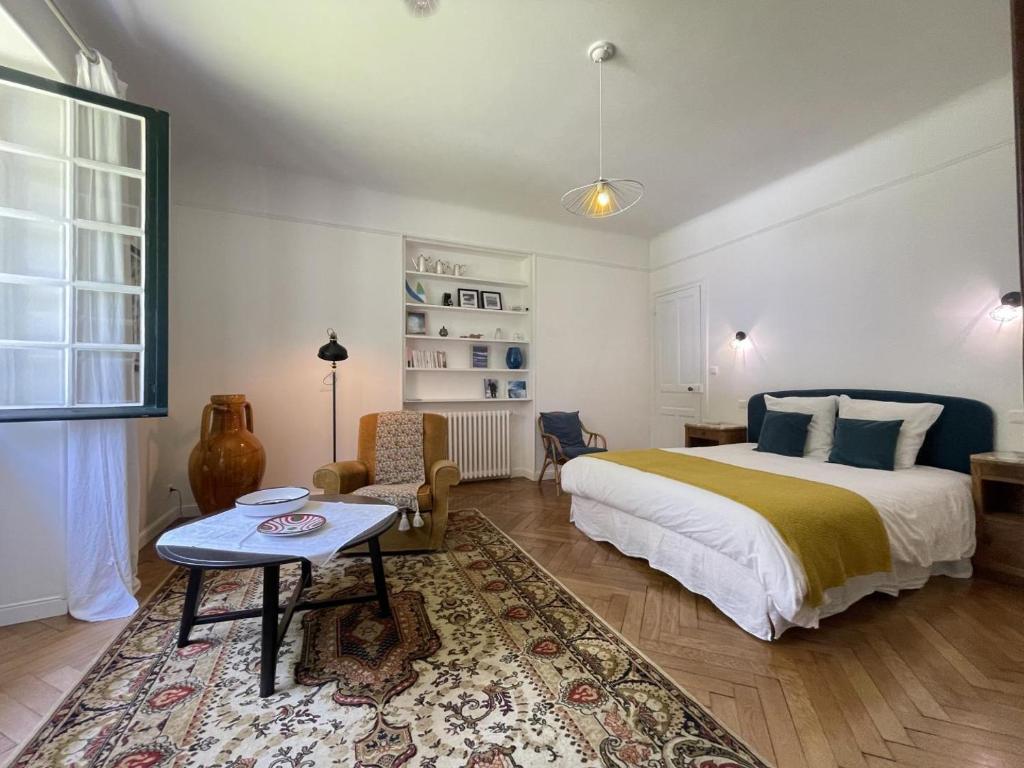 a bedroom with a bed and a table and a rug at Gure gostuan in Itxassou