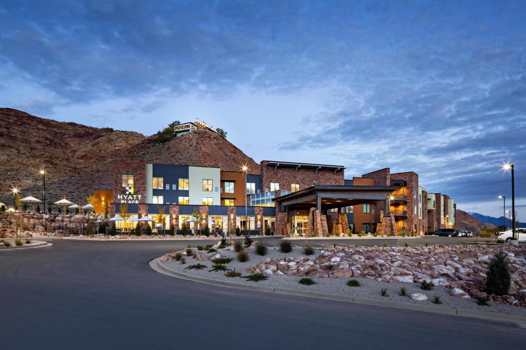 a building on a street with a mountain in the background at Hyatt Place Moab in Moab