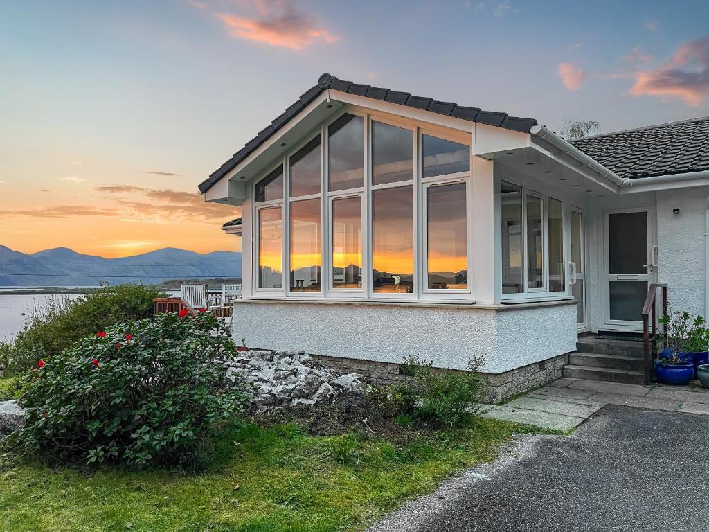 a house with large windows on the side of it at Creag Bheag in Appin