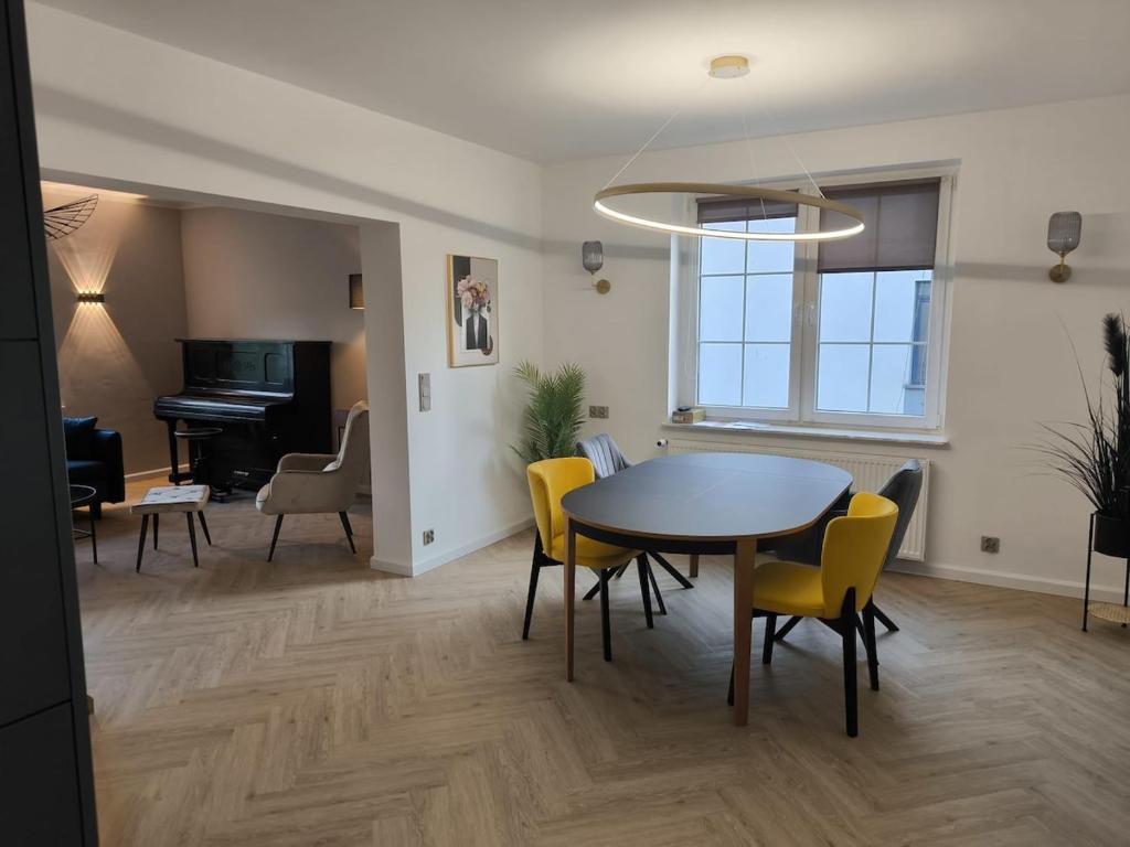 a dining room with a table and chairs and a piano at Gemütlich & stilvoll in Tuchola