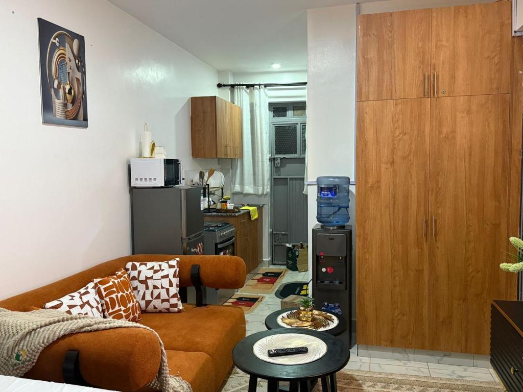 a living room with a couch and a kitchen at Membley star heights -Naivera in Ruiru