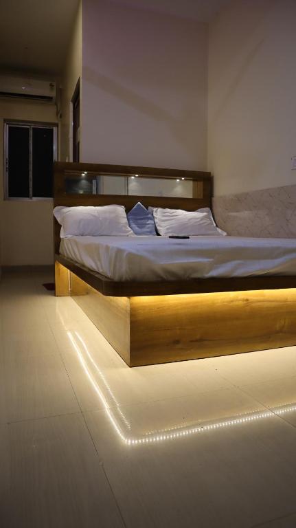 a bedroom with a large bed with a light on it at Tokyo Inn in Howrah