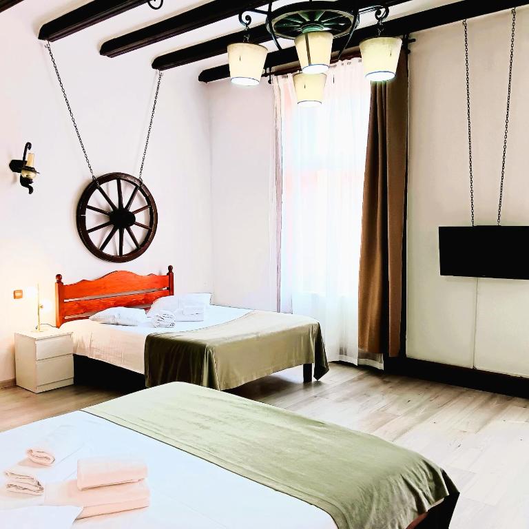 a room with two beds and a wheel on the wall at Noemi Old Town in Braşov
