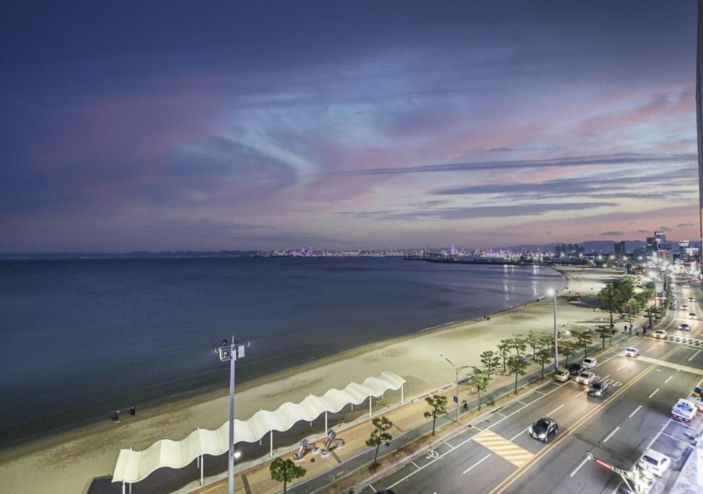 a view of a beach with a city and the water at Brown Dot Yeongildae Beach in Pohang in Pohang