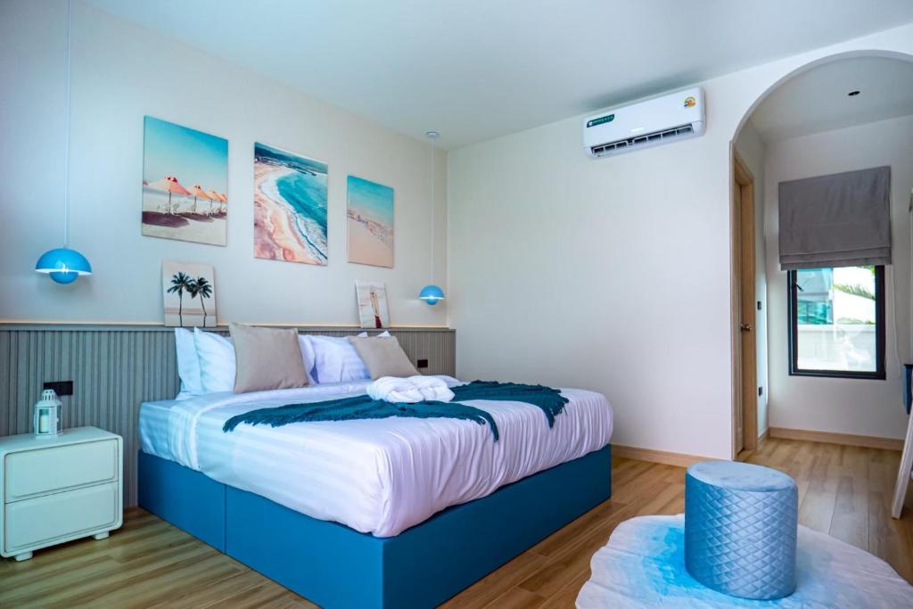 a bedroom with a blue and white bed at นารา พลูวิลล่า in Cha Am