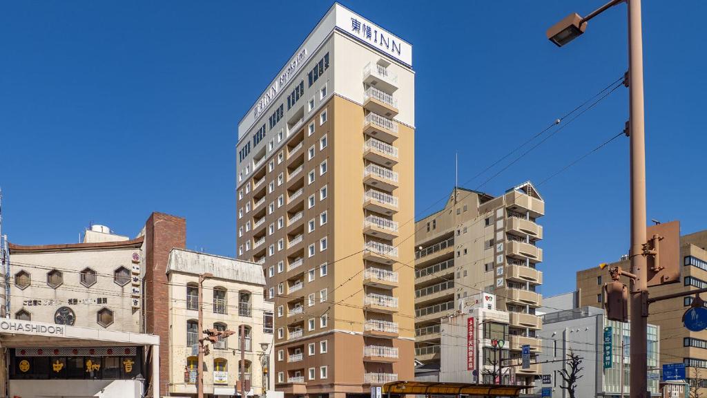 a tall building in the middle of a city at Toyoko Inn Kochi in Kochi
