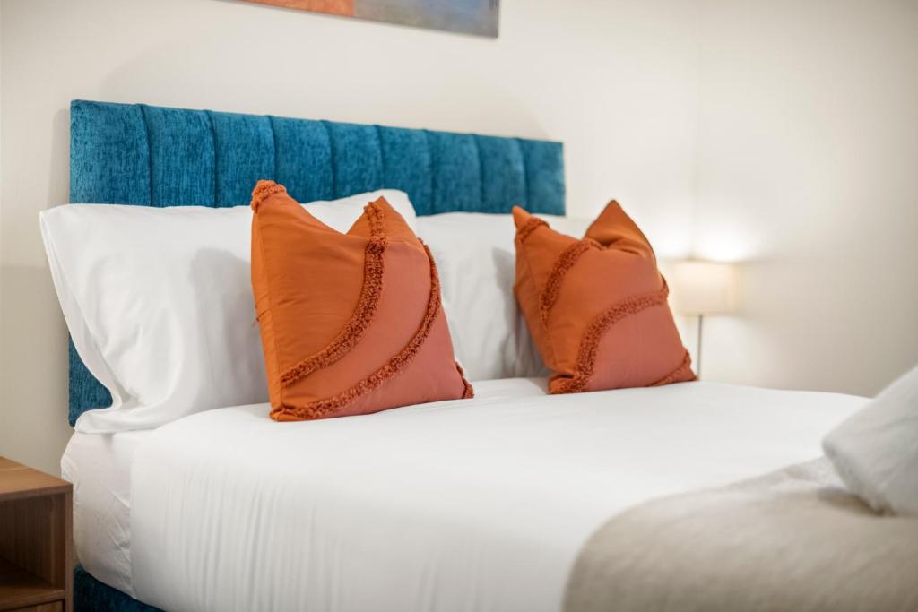 a white bed with four pillows on it at Stylish 3Bed, in Hemel Hempstead by ARP Homes, Free Parking, Perfect for Contractors in Leverstock Green