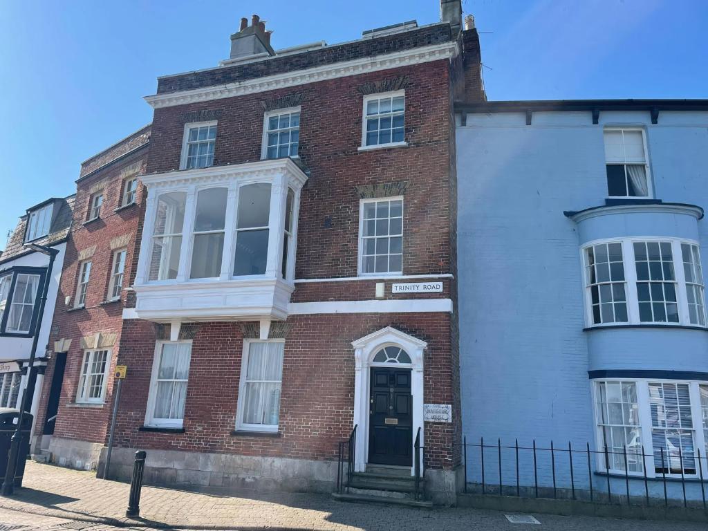 a red brick building with a door on a street at Monarch in Weymouth