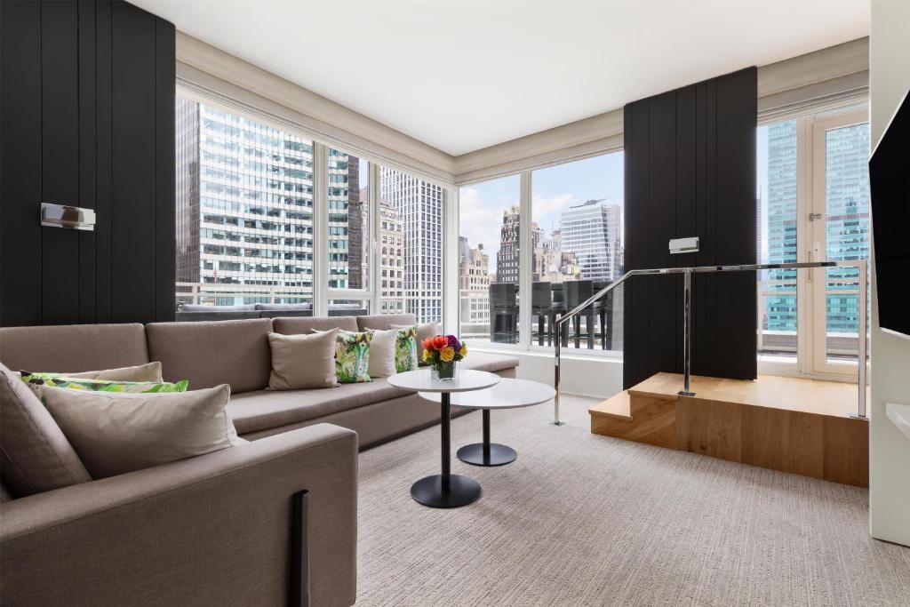 a living room with a couch and a large window at Andaz 5th Avenue, By Hyatt in New York