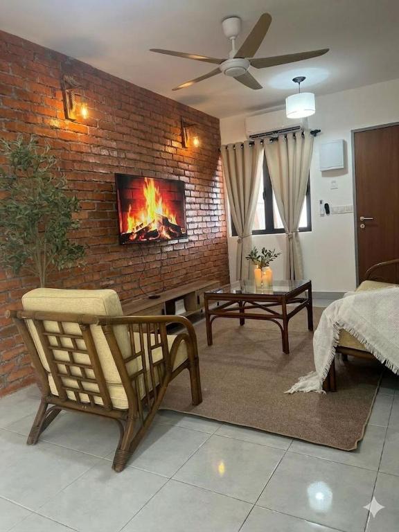 a living room with a brick wall with a fireplace at Duchess Home Taman Colonial in Raub