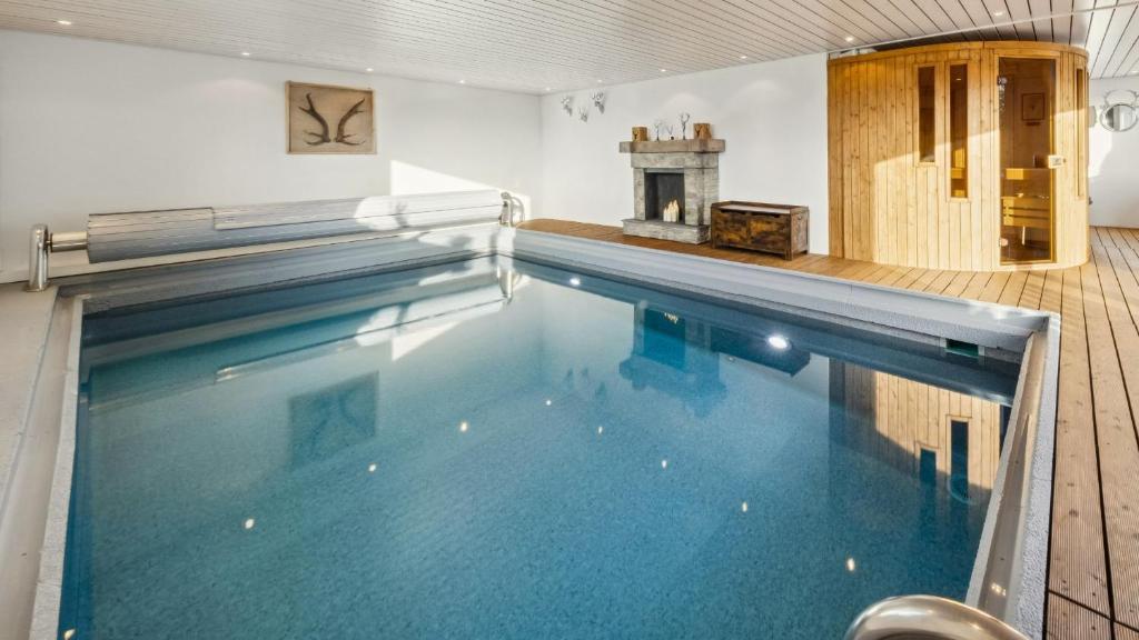 a large swimming pool with blue water in a room at Suite4you Erlen l Privater Indoorpool ganzjährig beheizt & Sauna l 10min zum Bodensee, Parkplatz & WLAN in Erlen