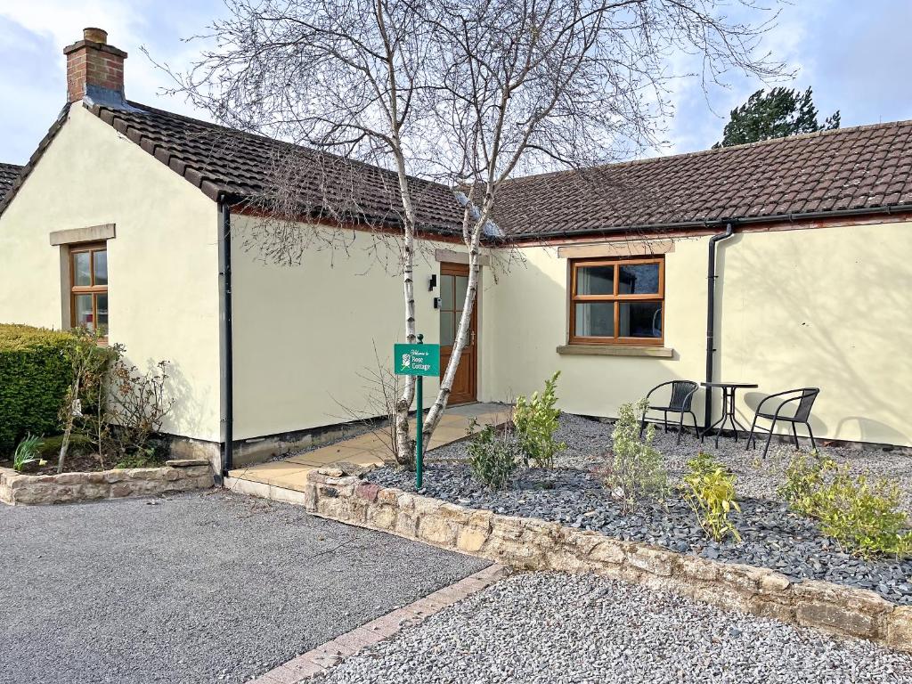 a white house with a table and chairs in front of it at Rose Cottage - Uk51373 in Winston