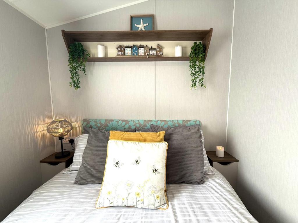 a bedroom with a bed with pillows on it at Dunlin Retreat in Flamborough