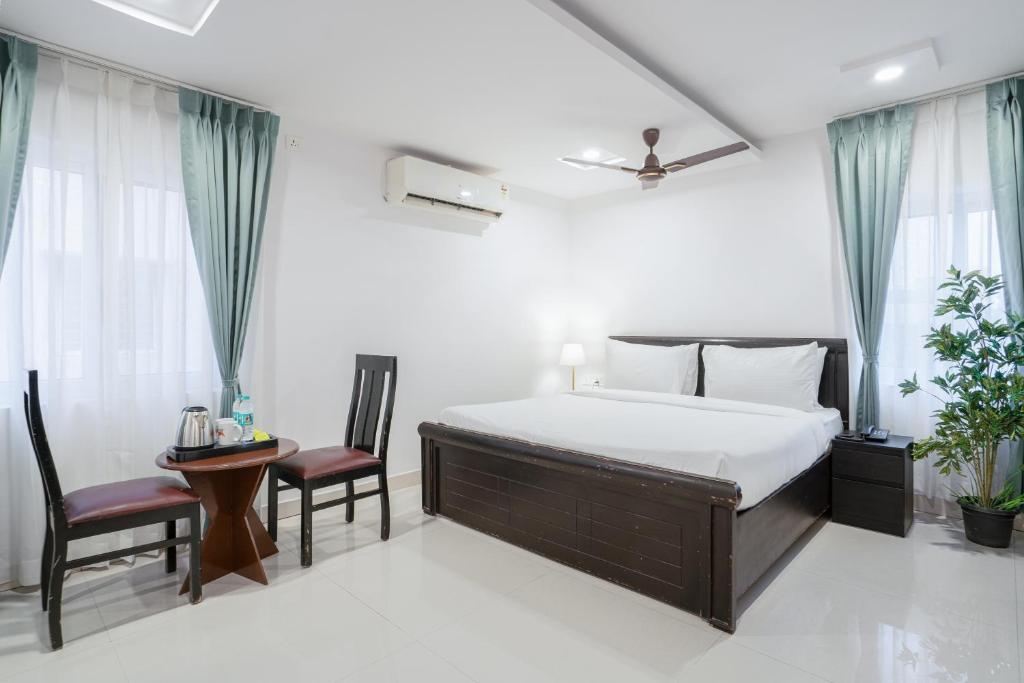 a bedroom with a bed and a table and chairs at RCC Hotels Parkview Inn Miyapur in Lingampalli