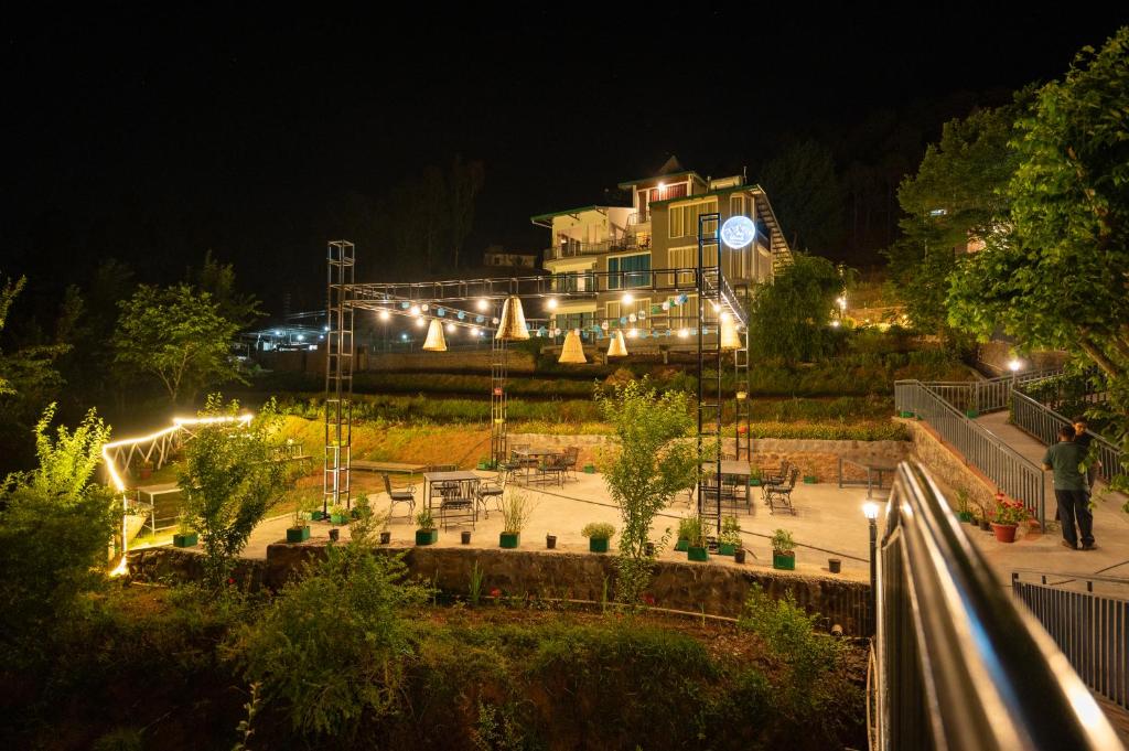 a large building with lights in a park at night at Tethys Himalaya Resort in Solan