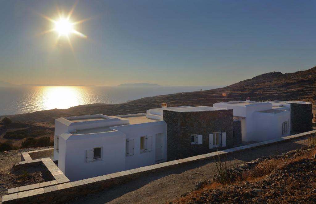 Áno MeriáにあるGreen Luxury Villasの日光を背景にした丘の上の建物
