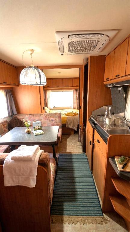 a small kitchen and living room in an rv at Caravan in the backyard in Šaľa