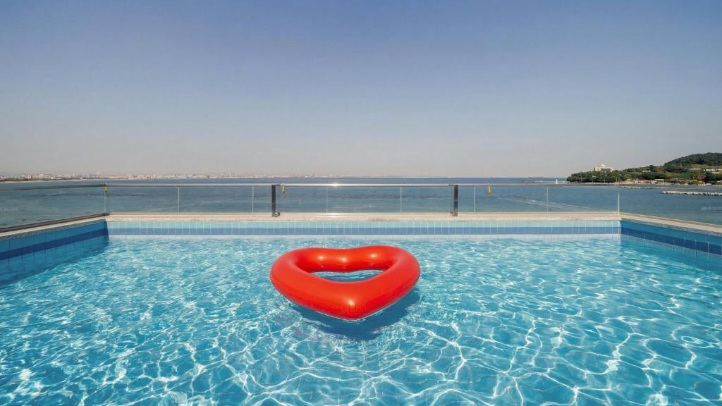 a red float in the water in a swimming pool at Pohang Etoile Poolvilla in Pohang