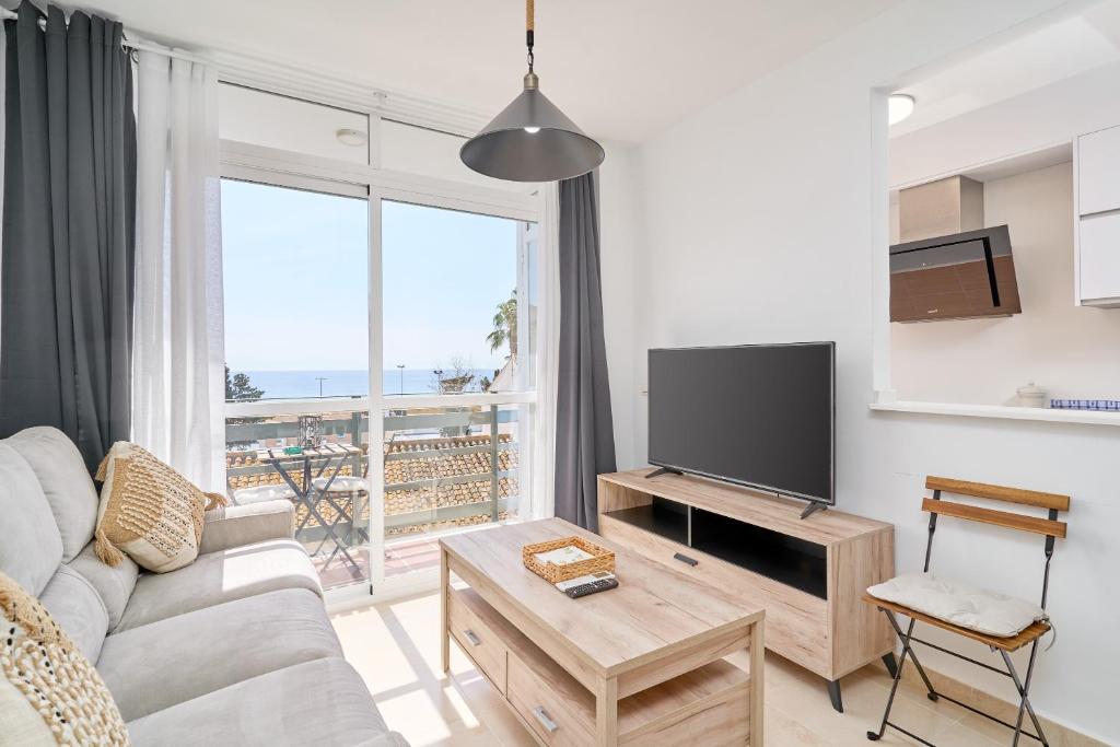 a living room with a couch and a flat screen tv at Marina De El Morche in Torrox