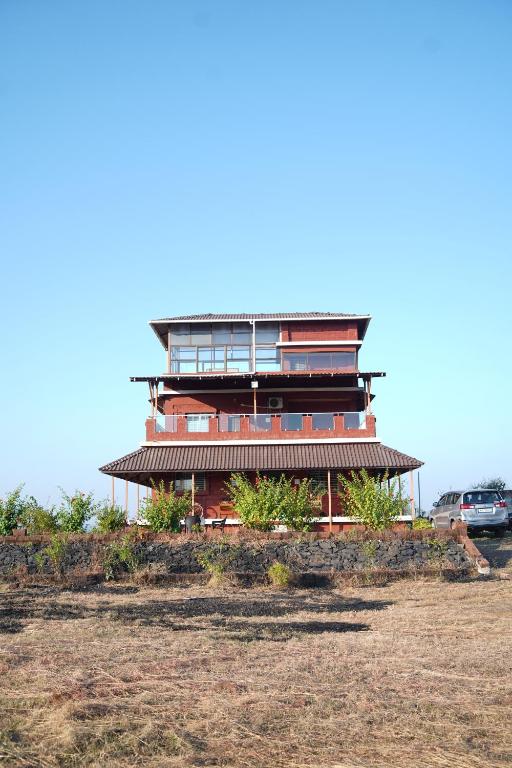 a large building on top of a hill at Sattva Gruha in Māngaon