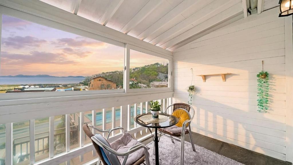 a balcony with a table and chairs and a view of the ocean at Ganghwa Daeun pension in Incheon
