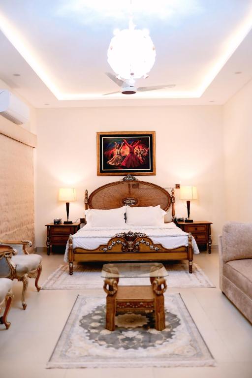 a bedroom with a large bed and a chandelier at The Grandeur Suite 1 in Rawalpindi