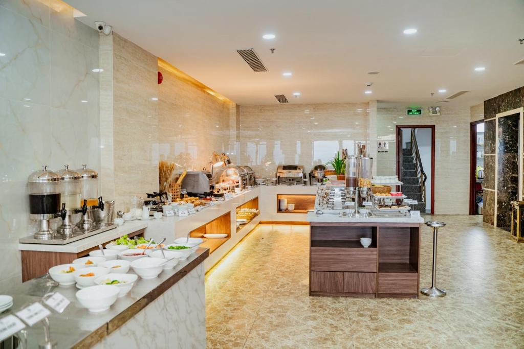A bright buffet breakfast room with counters, serving stations, and a central island.
