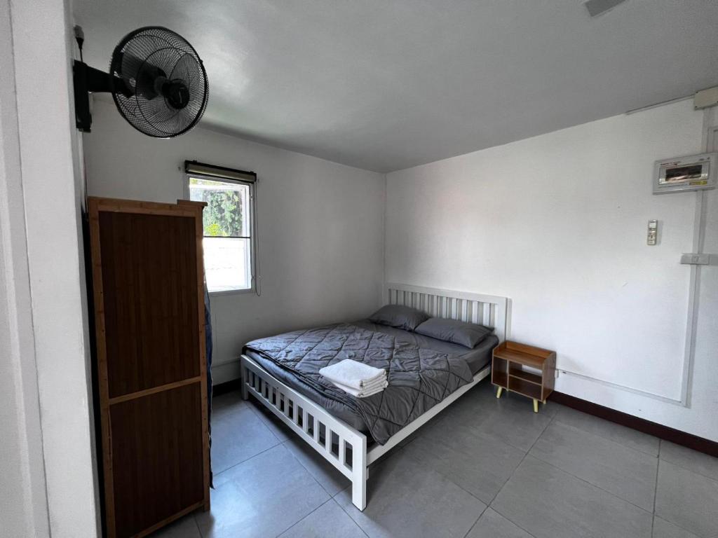 a bedroom with a bed and a fan on the wall at Ko Lipe Appartamenti in Ko Lipe