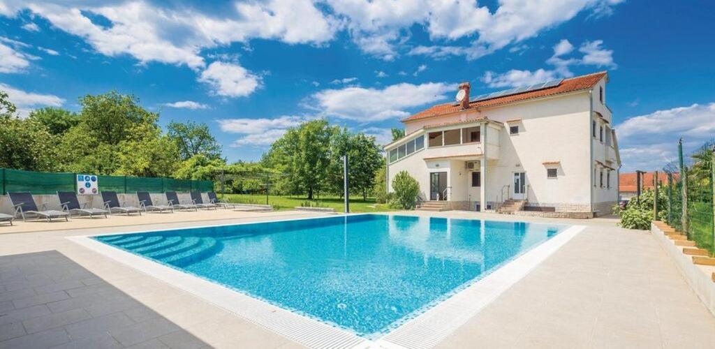 a swimming pool in front of a house at Apartments Suzy in Vantačići