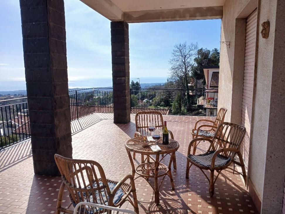 a patio with chairs and a table with a bottle of wine at At Armando's Home in Zafferana Etnea