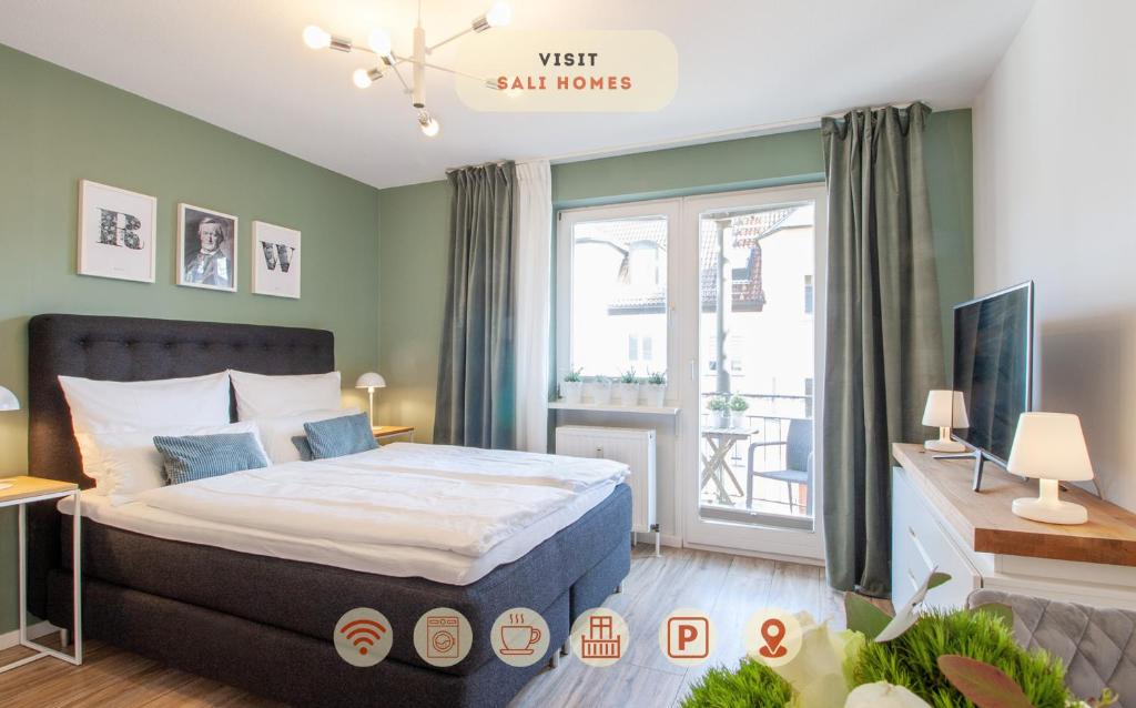 a bedroom with a large bed and a window at Sali Homes - Wahnfried No 1 City Apartment Balcony in Bayreuth