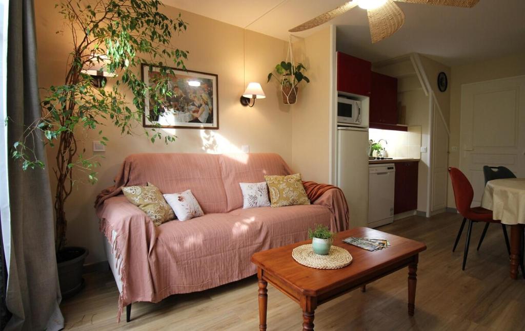 a living room with a couch and a table at Maison cosy 6 pers - piscine chauffée - nature et lac - Monflanquin in Monflanquin