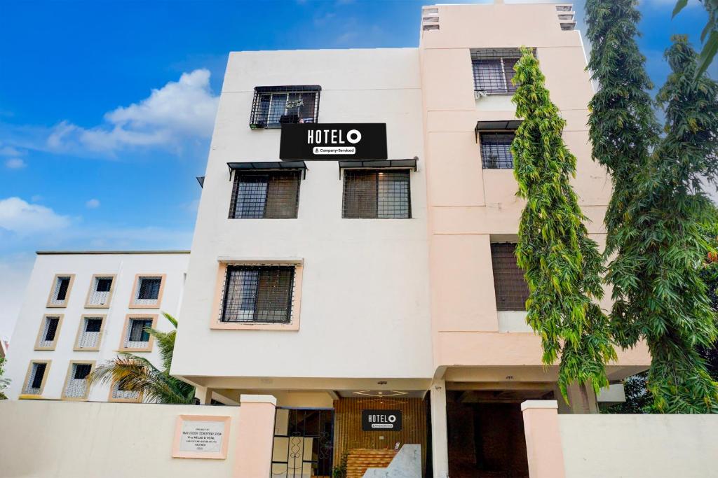 a white building with a sign on it at Super Hotel O Laxman Nagar Baner in Pune
