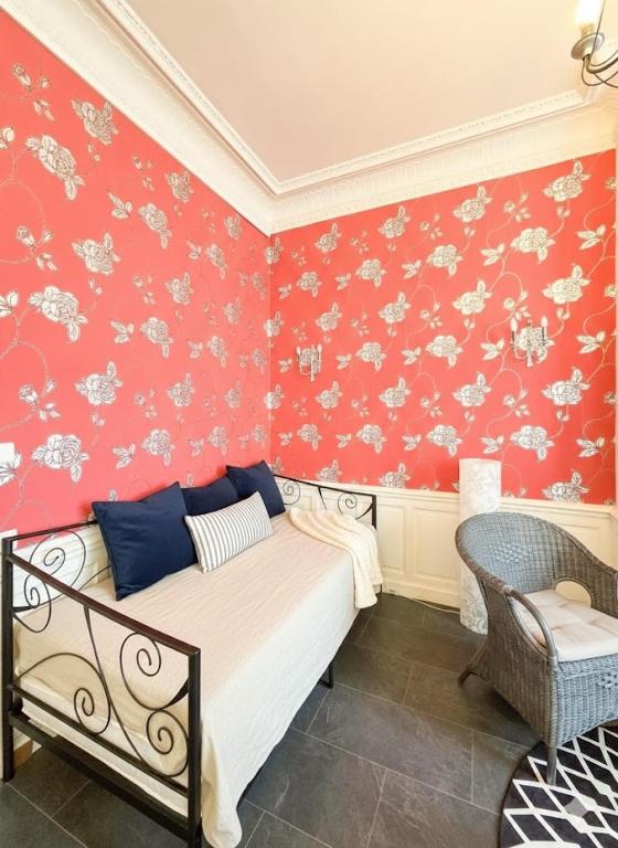 a bedroom with a bed and a red wall at Appart de charme, centre Vichy, Thermes in Vichy