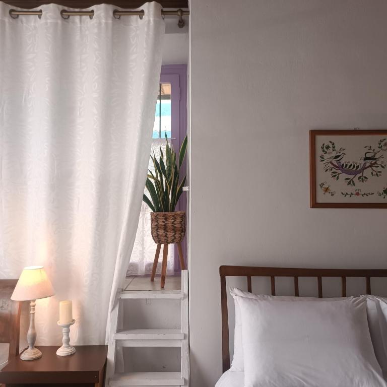 a bedroom with a bed and a white curtain at Oianthis house in Galaxidi