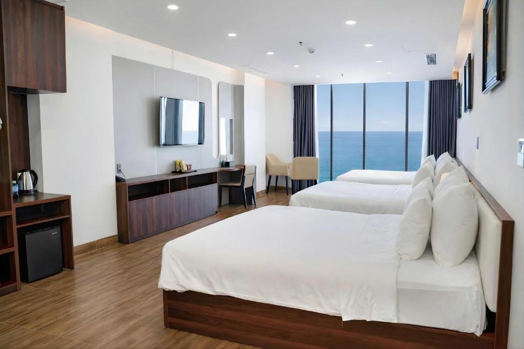 A spacious twin room with two beds, a long vanity desk and floor-to-ceiling ocean-facing windows.