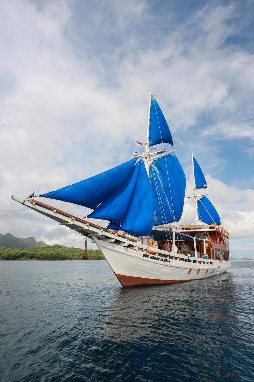 a boat with a blue umbrella on the water at Private Trip Labuan Bajo 2D1N in Labuan Bajo