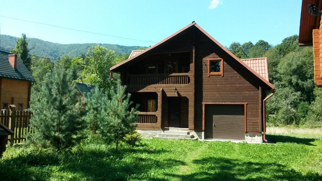 a brown house with a garage in a yard at Chalet TysaBorkut in Kvasy