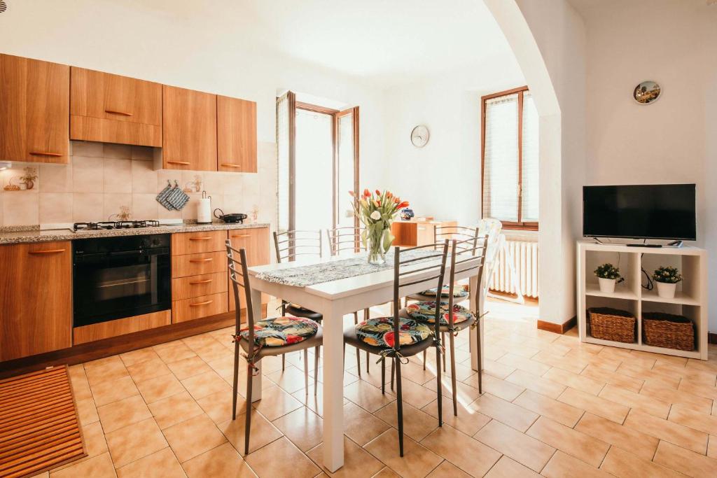 a kitchen and dining room with a table and chairs at Appartamento Ortensia - Meina in Meina