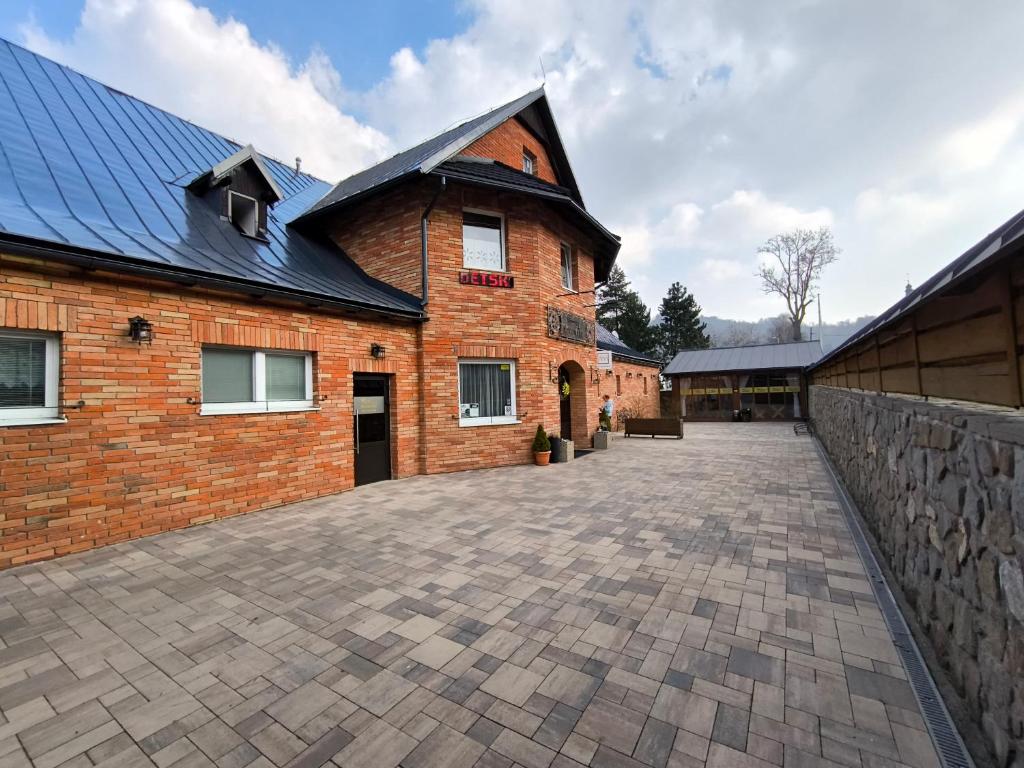 a large brick building with a large driveway at Hotel Koloniál Skalité in Skalité