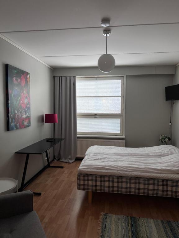 a bedroom with a bed and a window at Hostelli Palonkortteeri in Ilmajoki