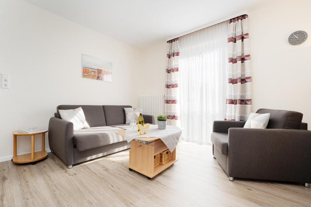 a living room with two couches and a coffee table at Haus Tweeflunken Wohnung 1 in Kellenhusen