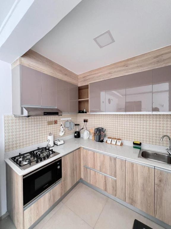 a kitchen with a stove and a sink at Sharz Cozy studio - Westlands in Nairobi