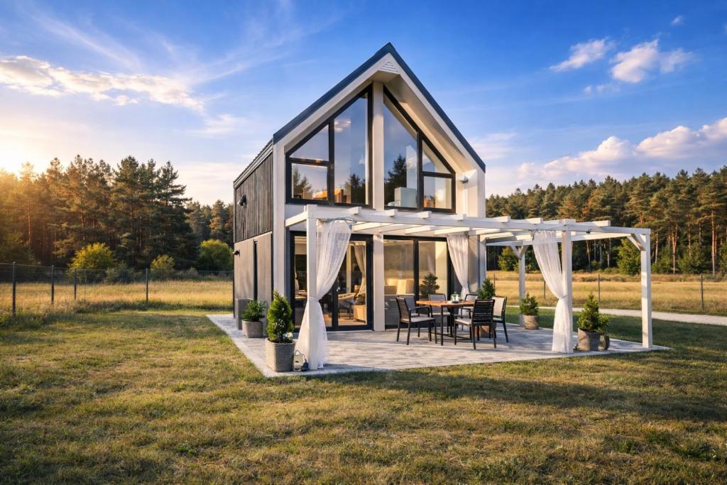 a house with a table in a field at Silvarium Kaszuby Domek Sosna in Stężyca