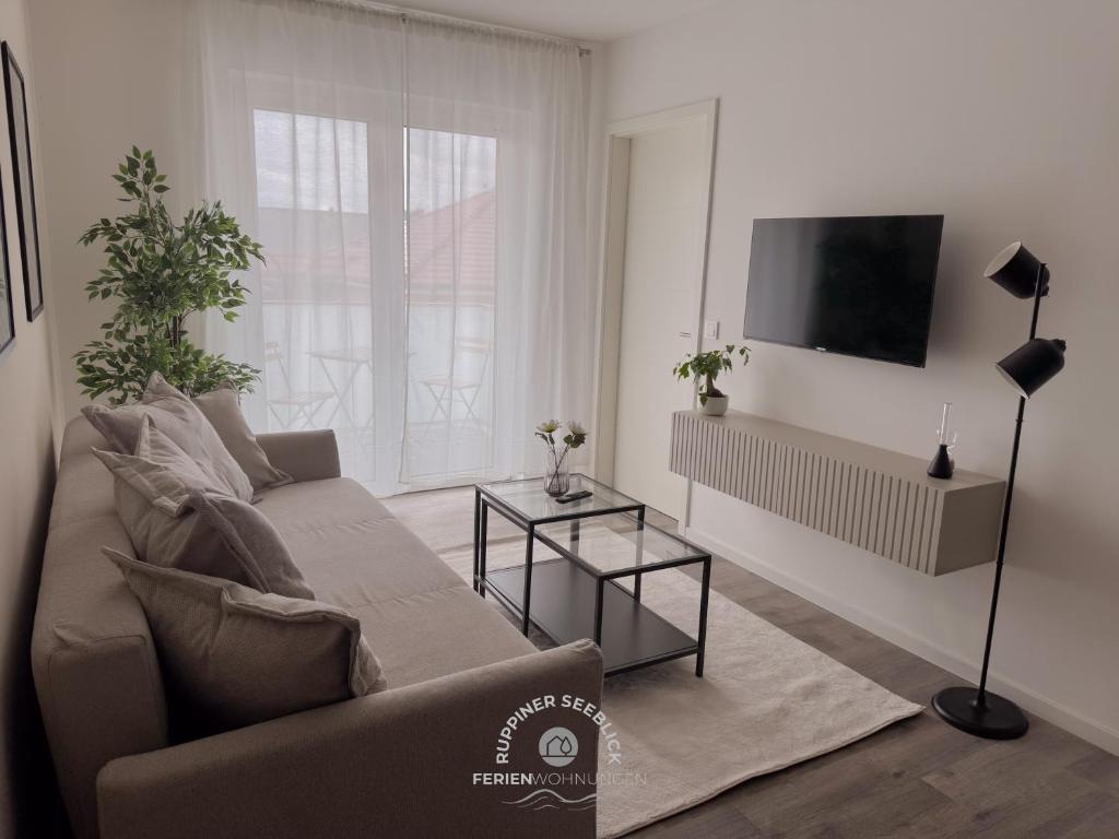 a living room with a couch and a flat screen tv at Ruppiner Seeblick Ferienwohnungen in Neuruppin