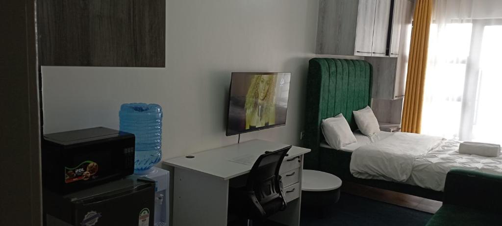 a small room with a bedroom with a bed and a desk at Starla, Duplex in Nairobi