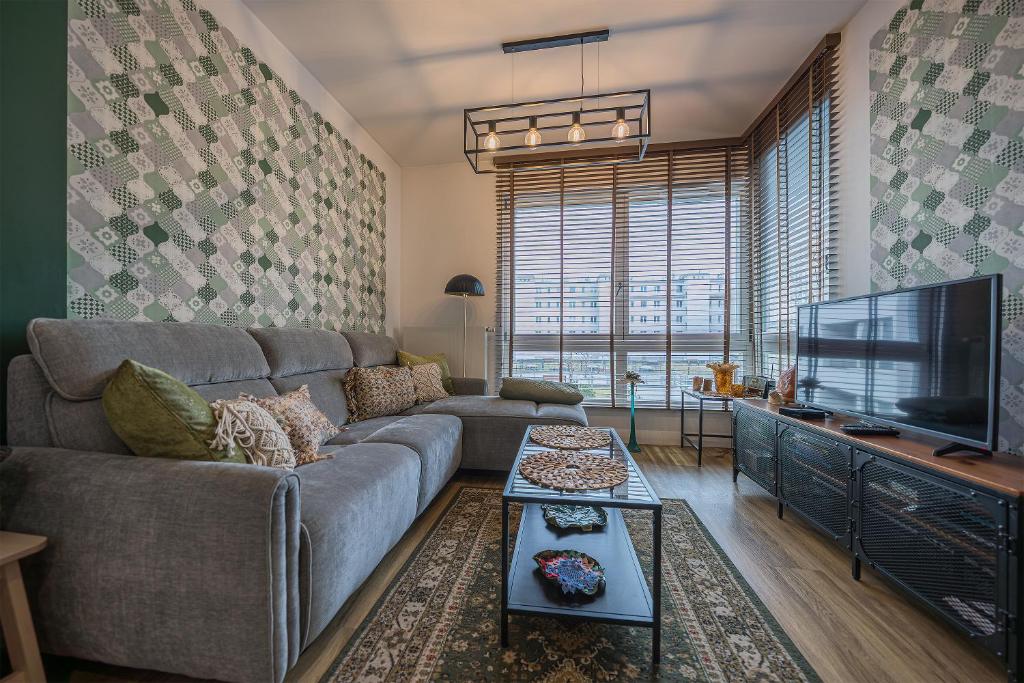 a living room with a couch and a flat screen tv at Comfort Apartments Batorego in Gdynia
