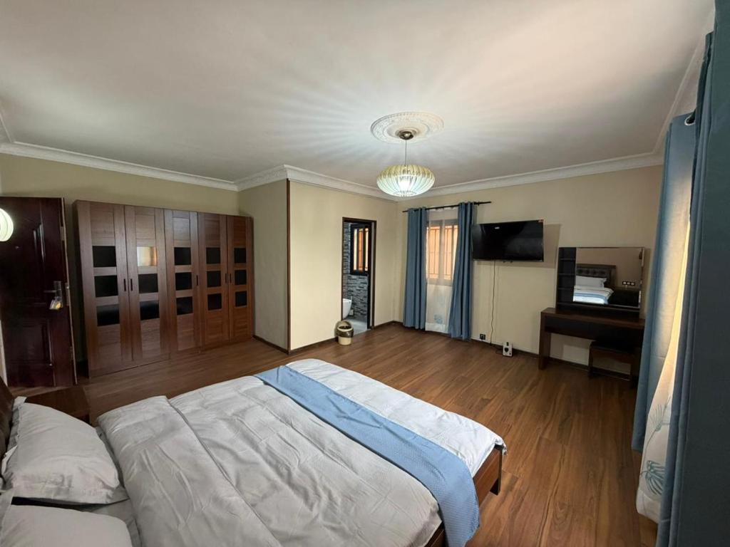a bedroom with a large bed and a television at GuestHouse Mendrika in Talata-maty