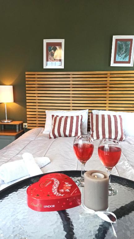 a bed with two glasses of wine on a table at Guest House Sunflowers in Pomorie